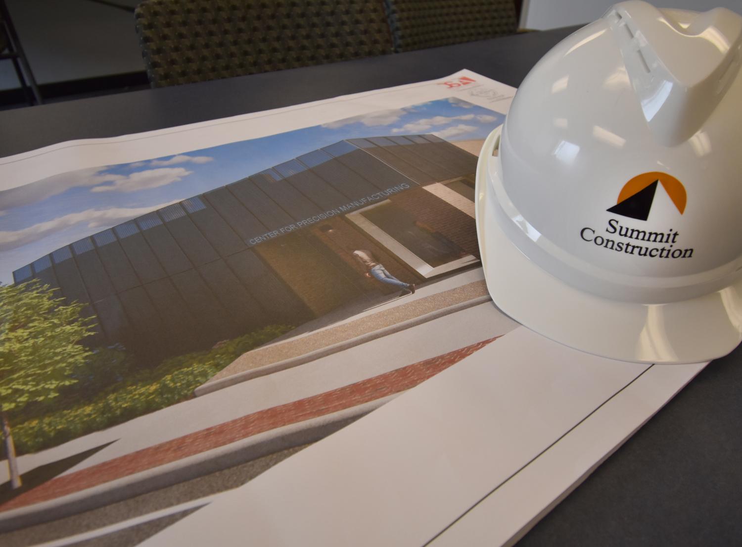 Summit Construction hard hat next to construction drawings 