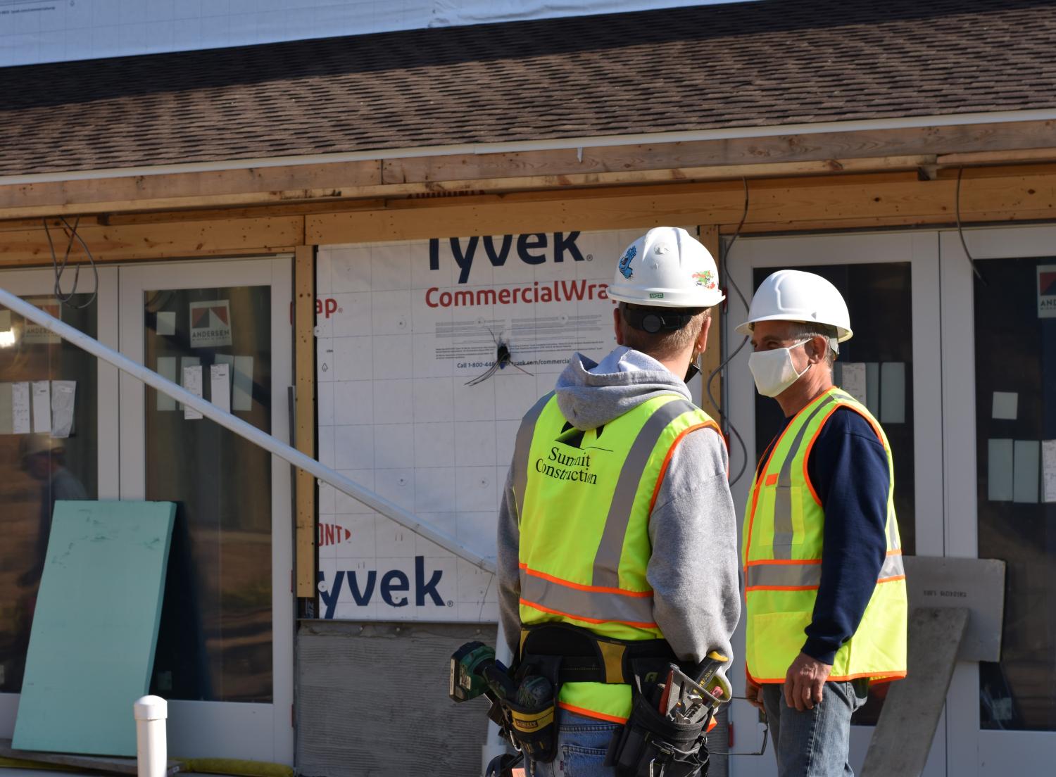 Construction managers with safety vests outside a project site