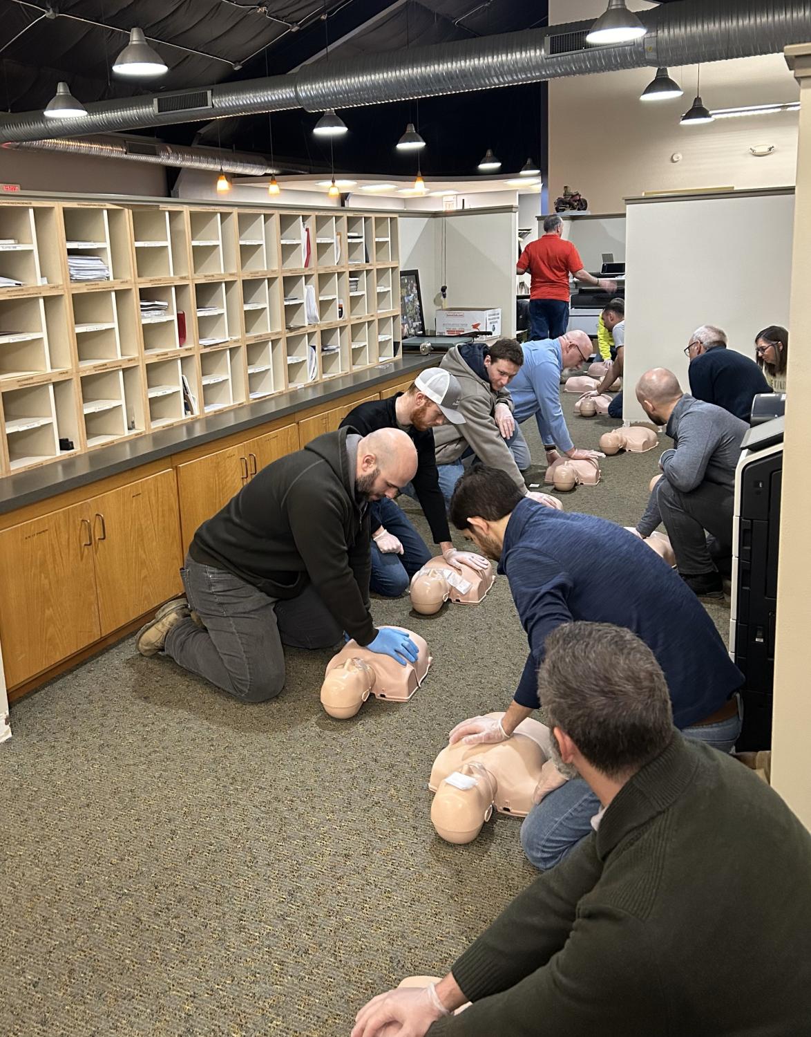 Akron office employees practice chest compressions. 