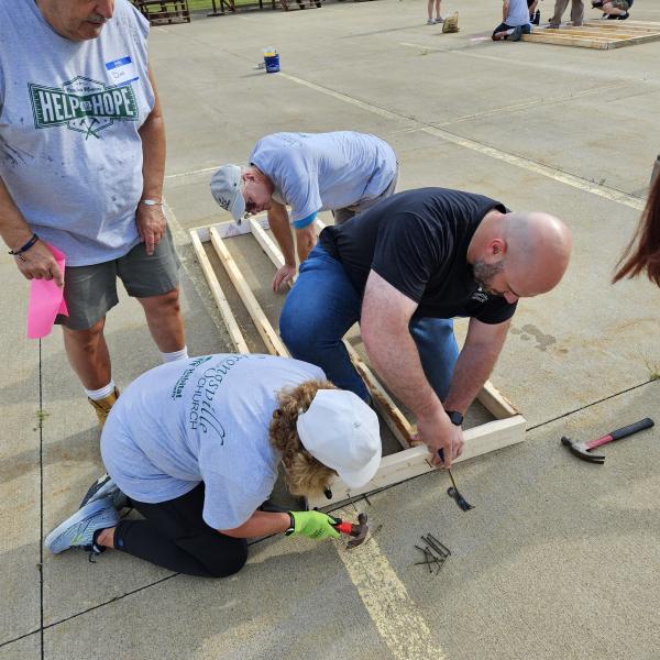 Chris Ciraldo helps another volunteer with the door frame